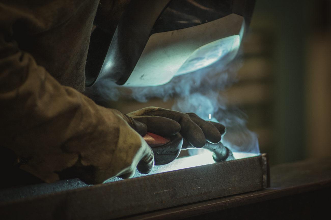 Professionelle Businessfotografie von Fotoagentur Otto in Goslar: Handwerker beim präzisen Schweißen von Metall, mit Schutzhelm und Handschuhen. Authentische Industriefotografie und Businessportraits für Unternehmen aus Goslar von Fotoagentur Otto.